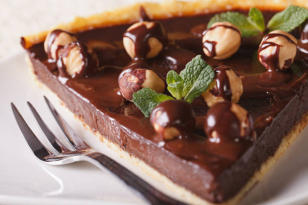 istock piece of chocolate tart with hazelnuts on a plate macro. 483402180