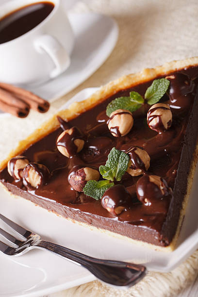 istock piece of chocolate tart with hazelnut and coffee. Vertical 483402348