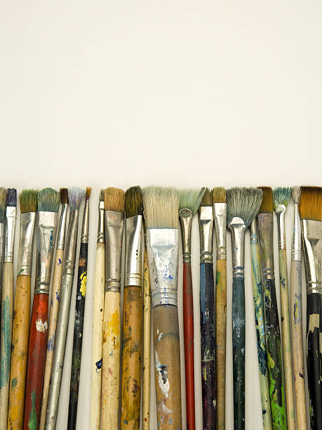 istock Well used art brushes on white paper with copy space 483405338