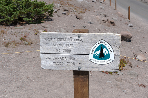 Timberline Lodge, Oregon, USA - August 4, 2015: A sign for the Pacific Crest National Scenic Trail No. 2000. Shows that from Timberline Lodge it is 550 miles to Canada and 2,108 to Mexico. Trail No. 2000 is part of the Pacific Crest Trail (PCT), a long distance trail the travels through California, Oregon and Washington. No snow is in this area at this time. This is near Government Camp, Oregon and about 60 miles (97km) east of Portland, OR. 