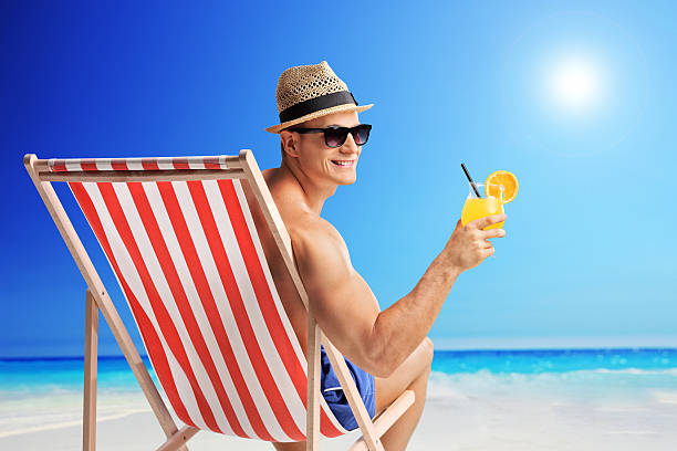 istock Joyful man holding a cocktail on a beach 483406944