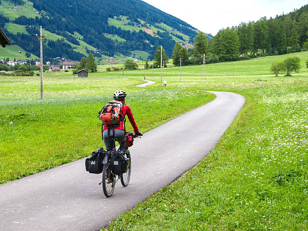 Woman riding a bike along river Drava in Austria
