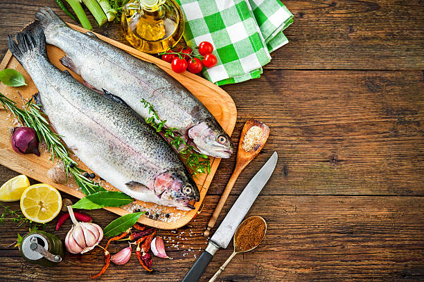 Fresh trout with spices and seasoning on cutting board