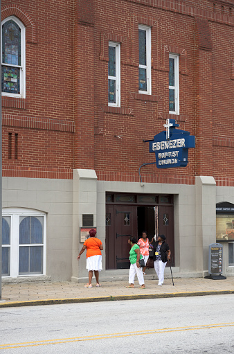 Atlanta, Georgia, USA - July 22, 2015: Four mature African American women are standing or walking outside the Ebenezer Baptist Church on a midday in summer. This is the church where Martin Luther King Jr. was baptized and both his father Martin Luther King, Sr. and he were pastors. The church was included in the National Historic Site when it was established on October 10, 1980.
