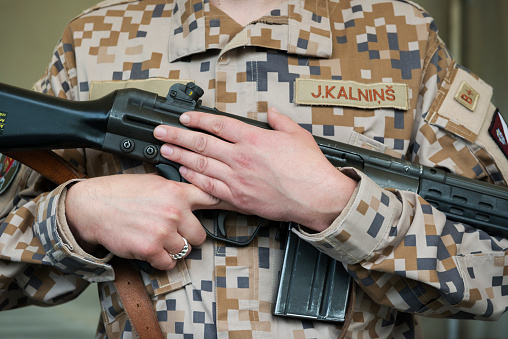 Riga, Latvia - August 1, 2015: A Latvia soldier in uniform holds a Swedish-made rifle in Riga, Latvia. He was one of many soldiers participating in an event celebrating the 100th anniversary of the Latvian Riflemen. Weapons were on display.