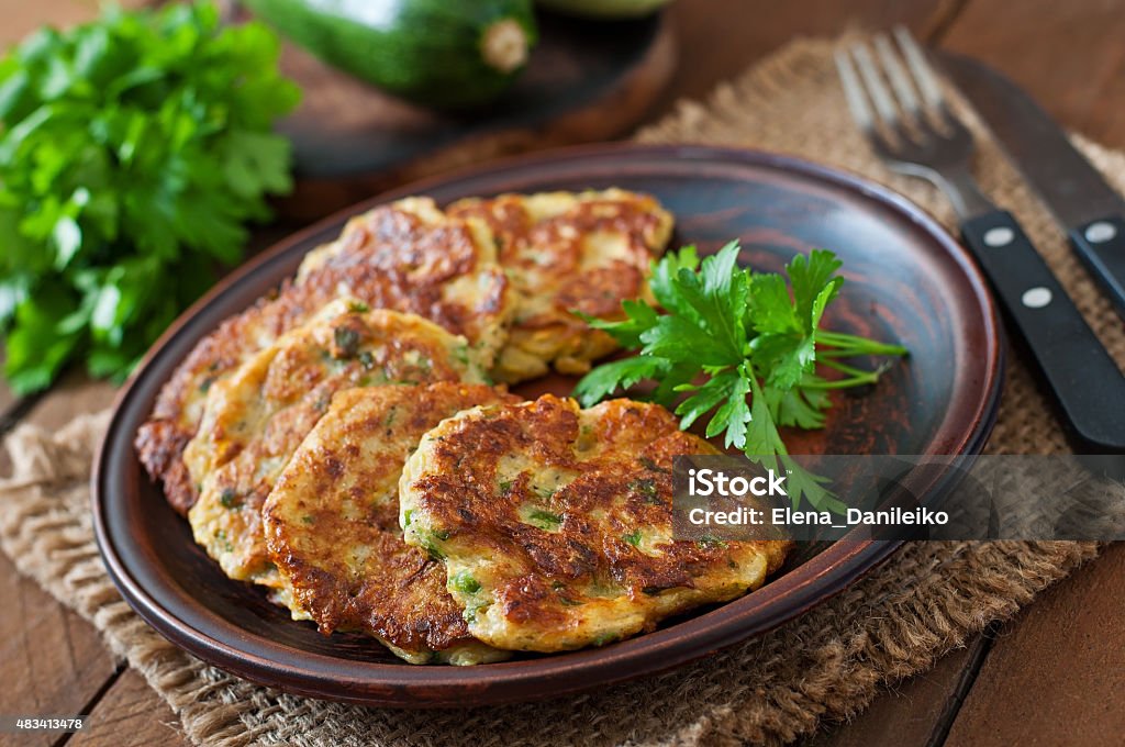Zucchini pancakes with parsley on a wooden table. 2015 Stock Photo