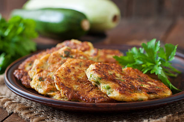 istock Zucchini pancakes with parsley on a wooden table. 483413480