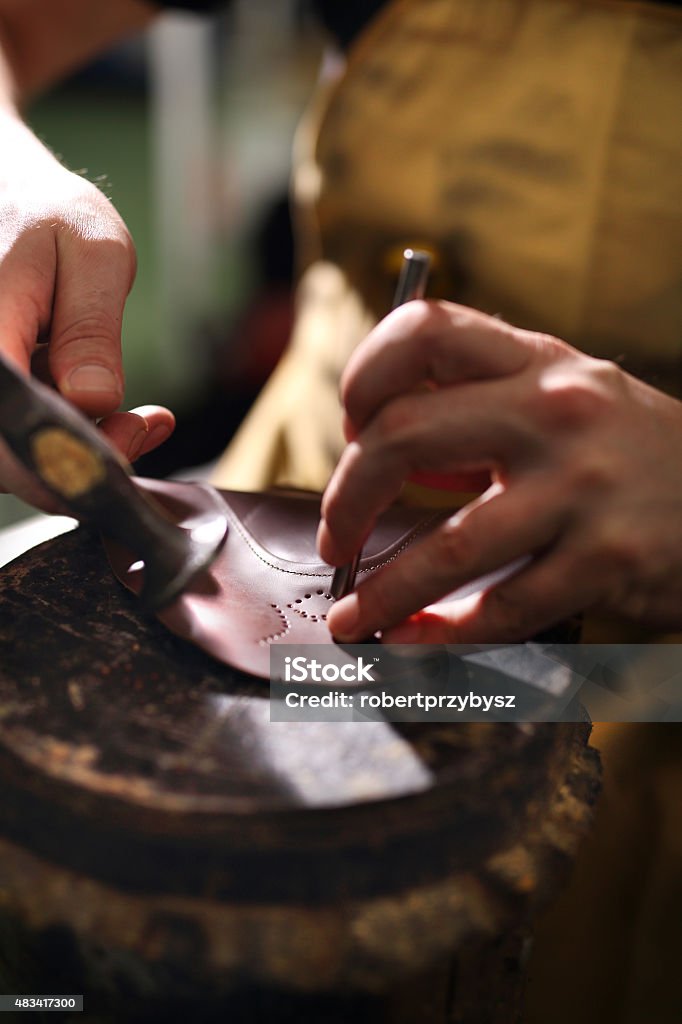 Punch skin for shoes. shoemaker makes chisel holes in the skin grain 2015 Stock Photo