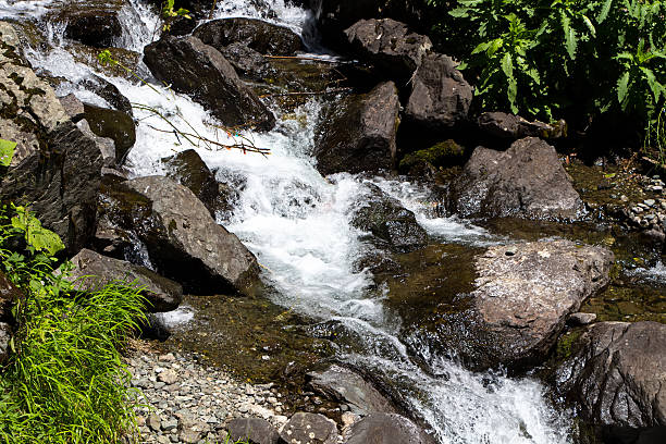 istock Image of flowing water among stones 483417322