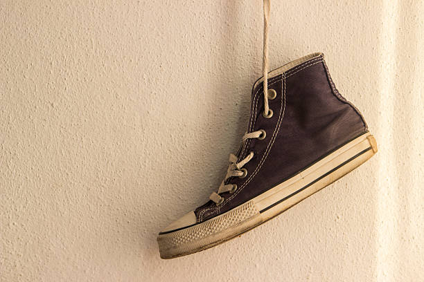 istock Old canvas shoe hanging on white wall 483417690