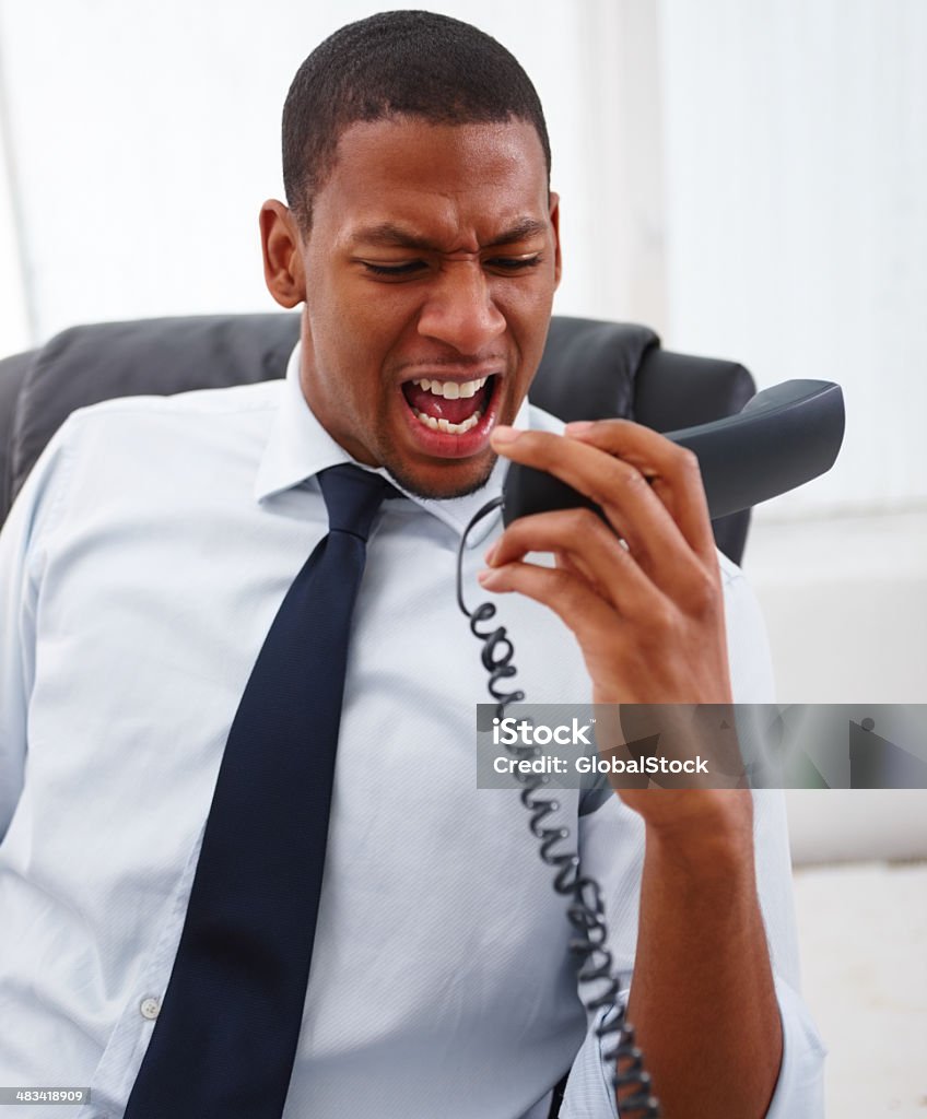 Uomo d'affari urlando sul telefono fisso - Foto stock royalty-free di Afro-americano