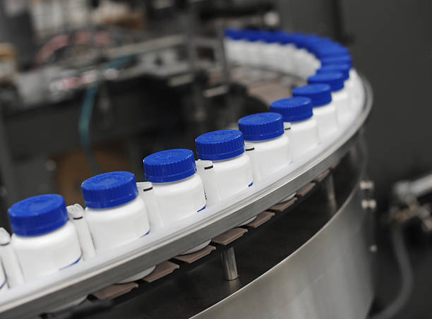 Blue Capped Drug Bottles on Conveyor stock photo