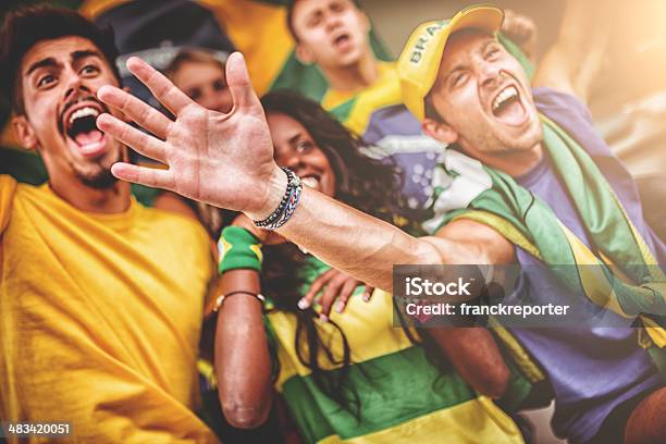 Group Of Brazilian Supporters At Stadium Stock Photo - Download Image Now - Adult, Arms Outstretched, Arms Raised