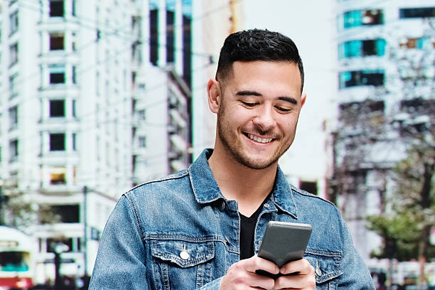 istock Smiling casual man using mobile outdoors 483421242