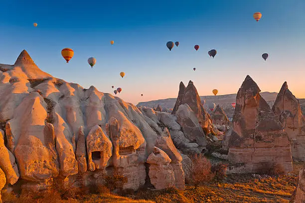 Hot Air Balloons rise up over the Goreme Valley in Cappadocia, Turkey