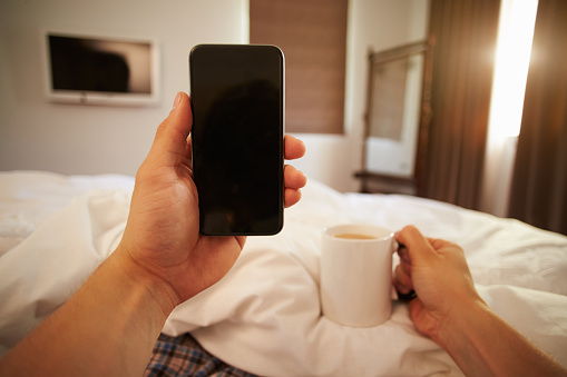 Point Of View Image Of Person In Bed Looking At Mobile Phone