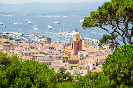 Looking from a viewpoint at the view of the town of Saint Tropez in France.  St Tropez is a popular French summer holiday resort. The colour image was taken on a hot summer day. St.-Tropez is a coastal town on the French Riviera, in the Provence-Alpes-Côte d'Azur region of southeastern France. Long popular with artists, the town attracted the international \