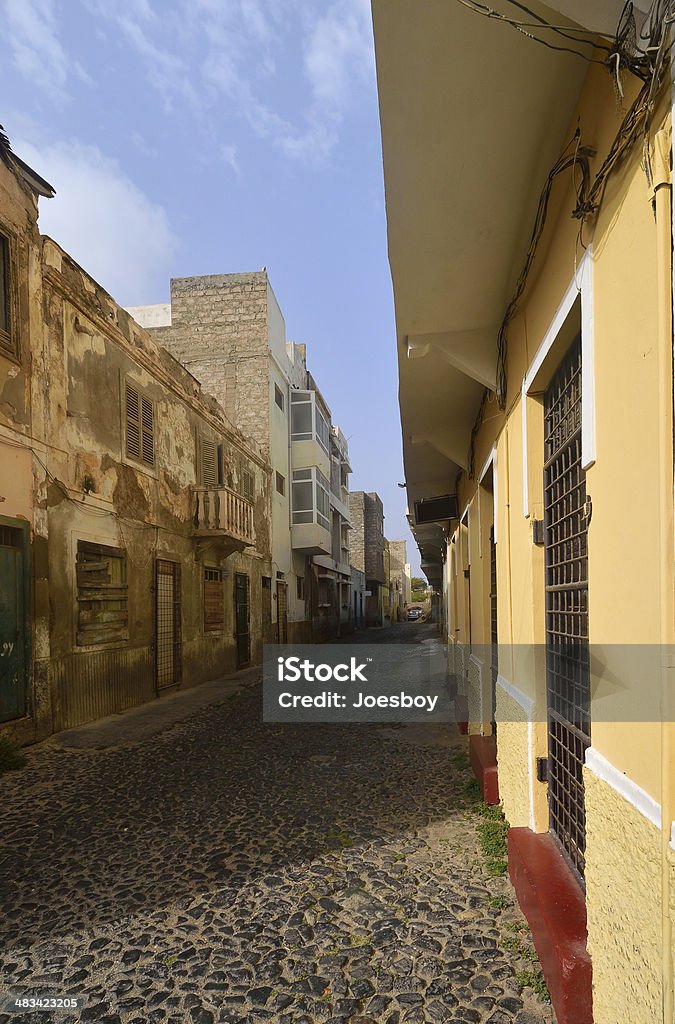 Mindelo Alleyway An alley off of Rua Santo Antonio, this cobblestone street in Mindelo on Sao Vicente in Cape Verde looks like many other streets. Not eh modernization of some of the buildings with overhanging oriels Alley Stock Photo