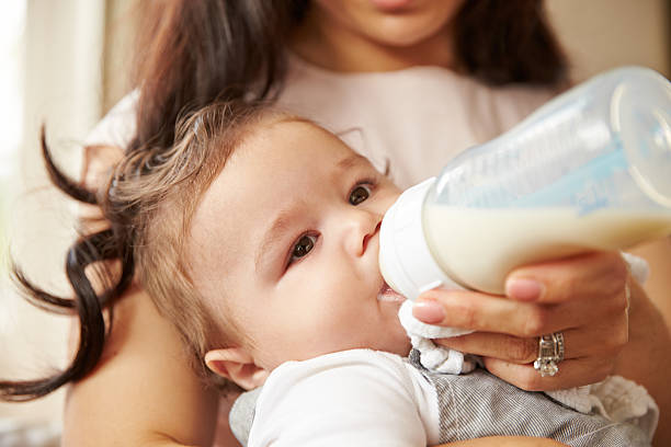 istock Mother Feeding Baby Boy From Bottle At Home 483426522
