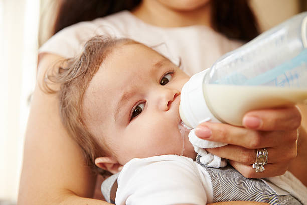 istock Mother Feeding Baby Boy From Bottle At Home 483426528
