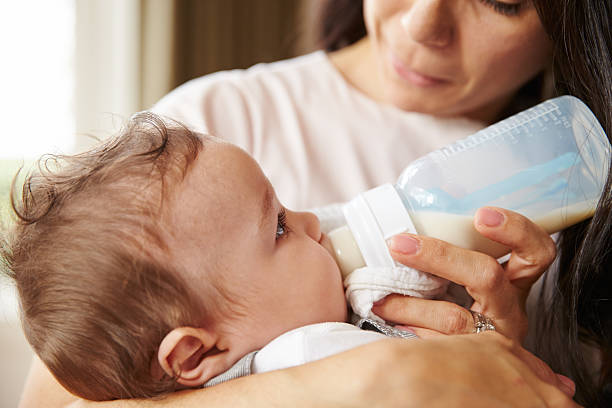 istock Mother Feeding Baby Boy From Bottle At Home 483426534