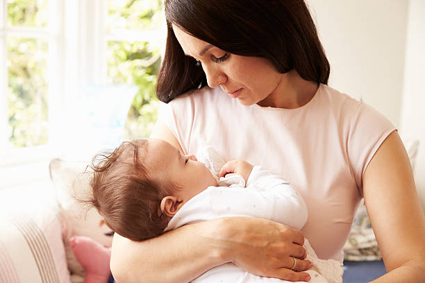 istock Mother Holding Sleeping Baby Boy At Home 483426656