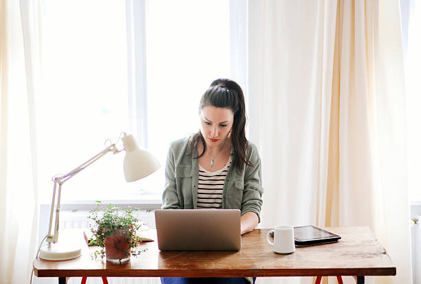 istock young brunette looking at laptop 483430124