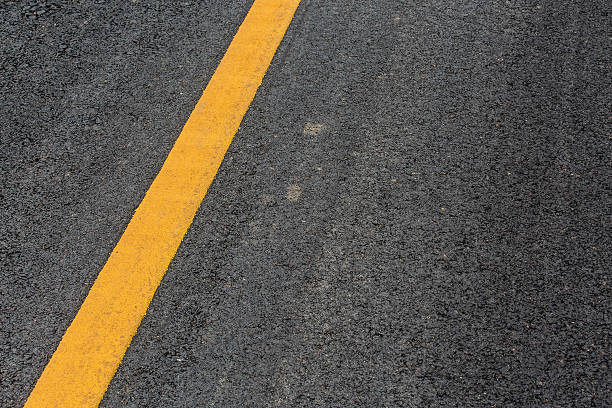 istock Yellow line on asphalt street road texture background 483431250