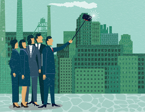 Business People Taking A Self-portrait Using A Selfie Stick. Business Selfie. They wear suits are are standing outside a factory.