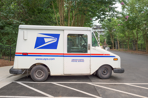 Atlanta, Georgia, USA - July 23, 2015: A white, blue and red USPS (United States Postal Service) truck used to deliver mail parked in a residential area in Kennesaw - a city in Cobb County, Georgia, United States, located in the greater Atlanta metropolitan area.