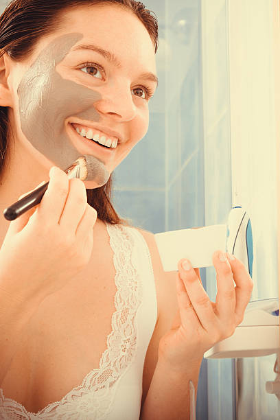 istock Woman applying mud facial mask 483446730