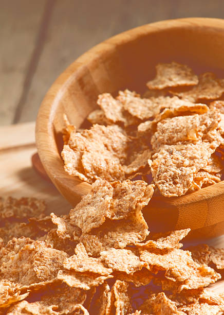 istock Wheat flakes poured from a wooden bowl 483447960