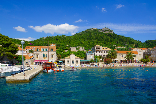 Lopud, Croatia - June 27, 2015: Scene of the fishing port and the beach, with boats, locals and tourists, in the village Lopud, Lopud Island, one of the Elaphiti Islands, Croatia