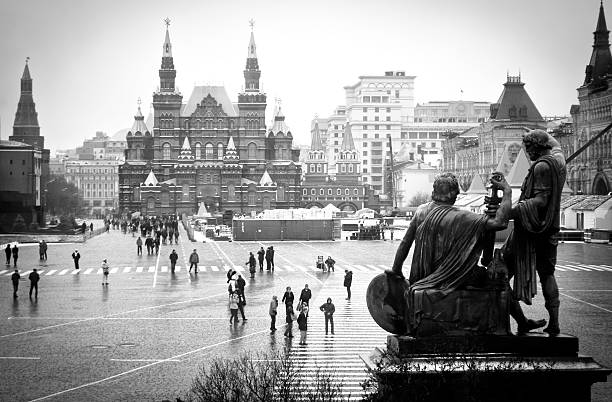 Moscow, Russia - November 17, 2011: View of Red Square in black and white with museum of Russian History on the background statue on the first floor and people walking along the square