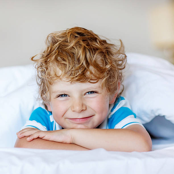 istock Little blond child sleeping in his bed with toy. 483451596