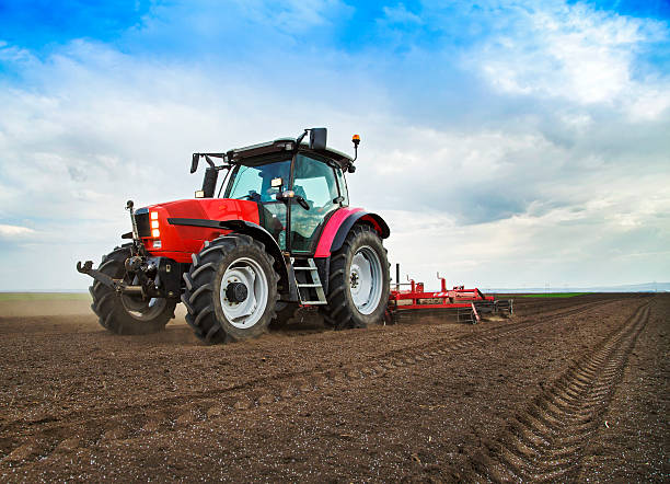Farmer in tractor preparing land for sowing