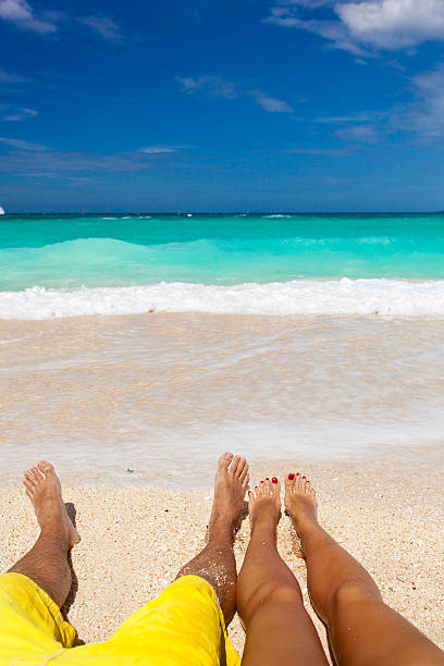 istock Male and female legs on tropical beach 483453077
