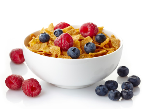 Bowl of corn flakes and fresh berries isolated on white background