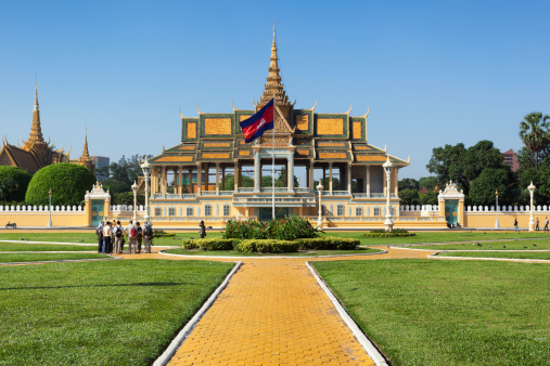 Phnom Penh, Cambodia - December 2, 2013: A group of tourists gathers in the Royal Palace park in front of the iconic Chan Chhaya Pavilion, also known as the Moonlight Pavilion.