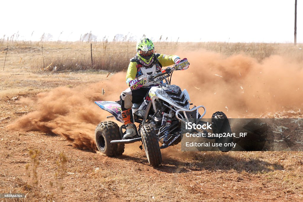 Quad Bike kicking up trail of dust at rally Koster, North West Province, South Africa - July 11, 2015:  Africa-Offroad Racing Rally.  Quad Bike kicking up trail of dust on sand track during rally race. 2015 Stock Photo