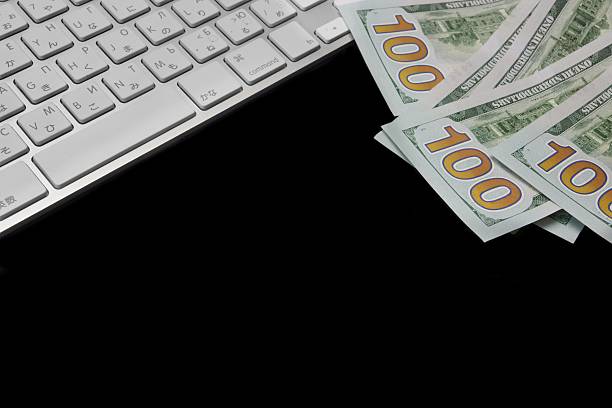USA Dollar Bills And Wireless Keyboard Isolated On Black Background