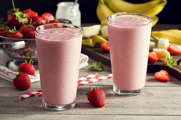 deux smoothies au yaourt à la fraise et à la banane des verres avec des produits - cocktail à la fraise photos et images de collection