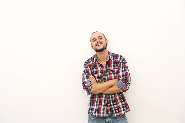 istock Smiling young man with beard standing against white wall 483470968