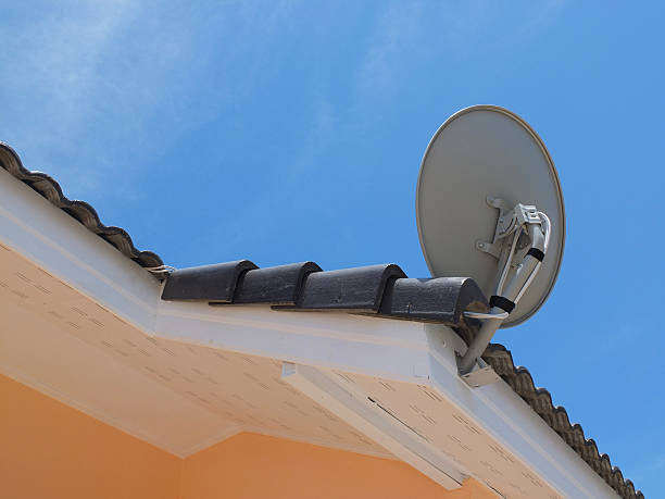 istock White satellite dish with blue sky on roof 483475360