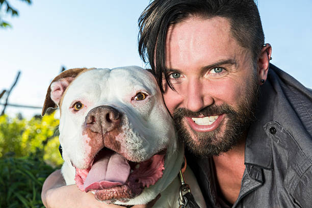 istock Smiling Man with His Pit Bull Dog Outdoors 483479504