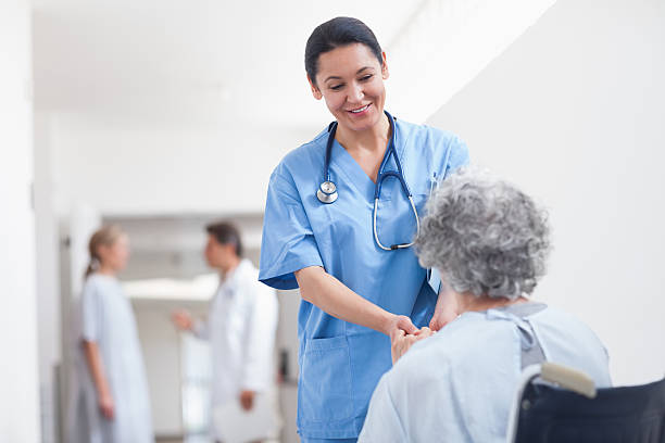istock Nurse standing next to a patient while holding her hands 483482109