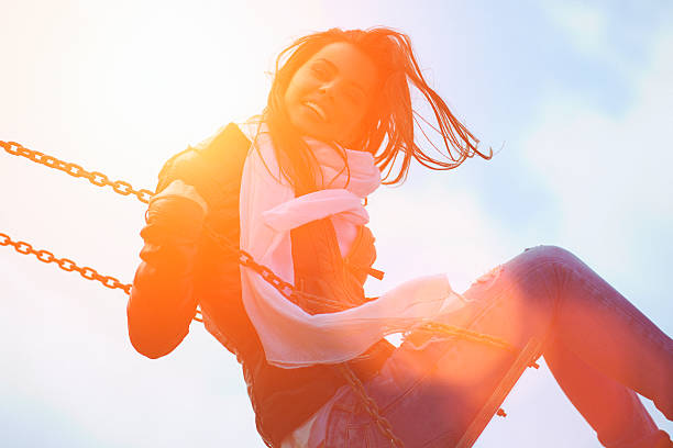 istock Young woman having fun swinging in sunlight 483483217