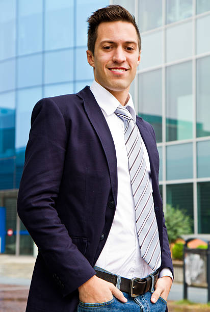 istock Smiling young businessman standing outside a building 483483845