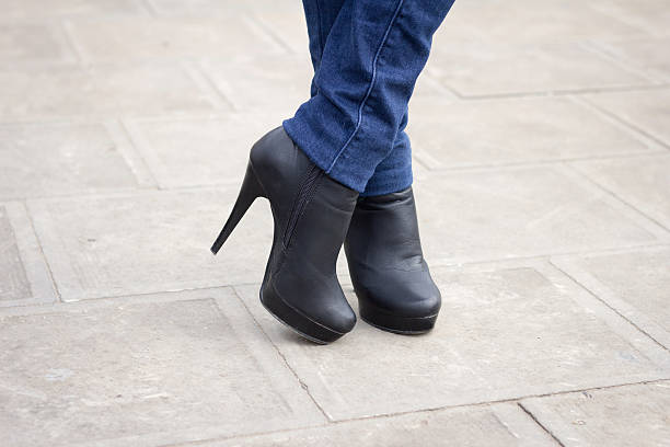 istock Girl's leg with black boots on a high heel. 483484397