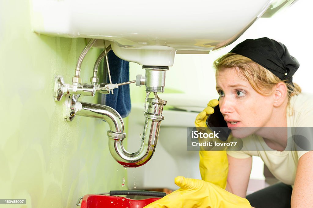 Hausfrau einem Muschelkiemen unter dem Waschbecken - Lizenzfrei Abfluss Stock-Foto